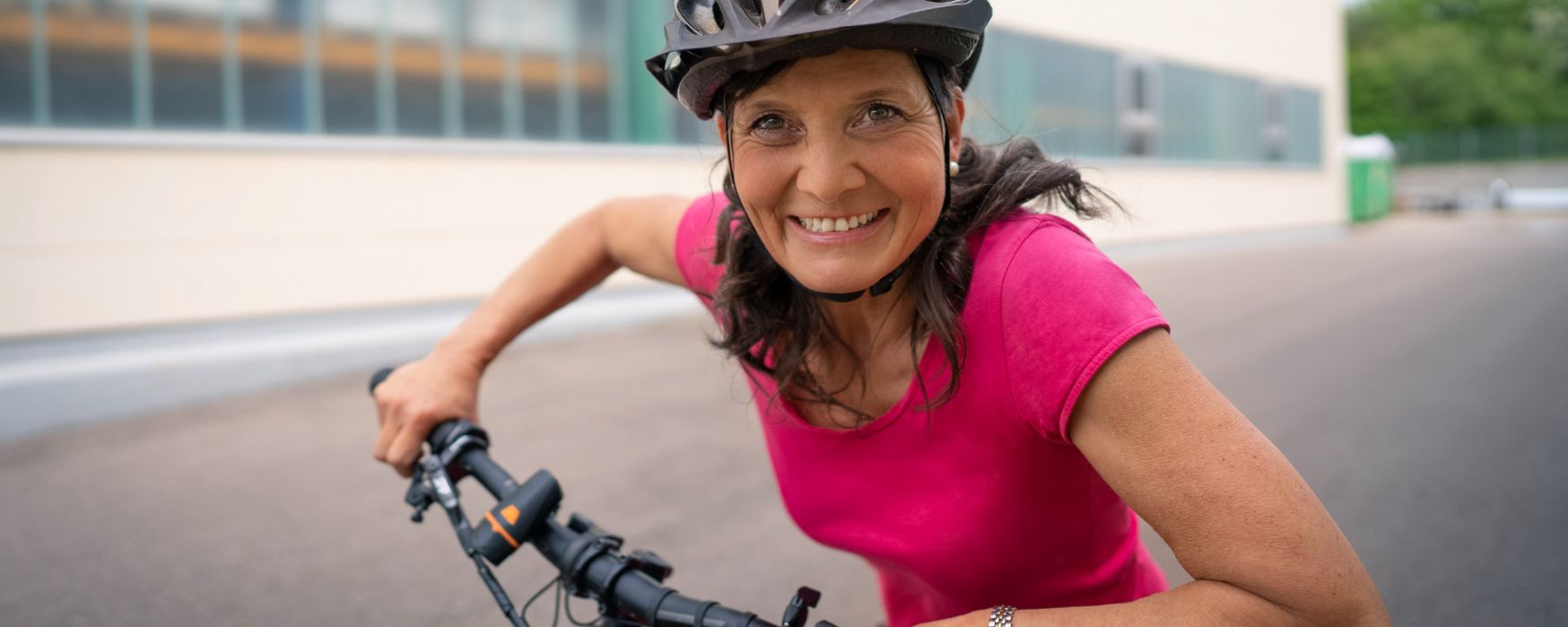 Frau sitzt auf dem Fahrrad und schaut in die Kamera